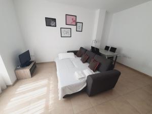 a bedroom with a bed and a couch and a tv at Luxury Apartments Puerto Valencia in Valencia