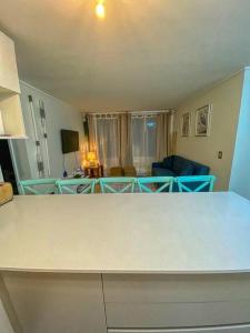een woonkamer met een witte tafel en een bank bij Hermoso y acogedor departamento a un paso de todo! in Papudo