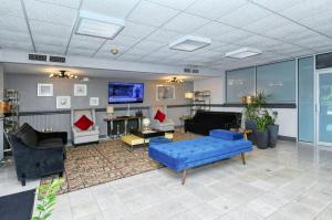 a living room with a blue couch and a tv at Heated Pool, Bunk Beds, King Bed, Huge TV, Marina, Tiki Bar in Sarasota