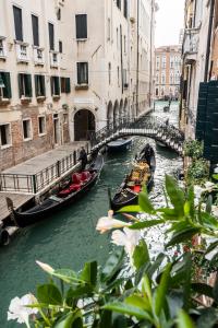 twee gondels in een kanaal in een stad met gebouwen bij Giò&Giò Venice B&B in Venetië