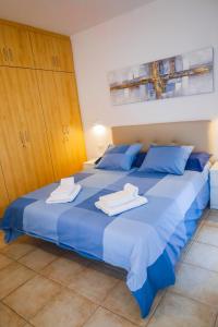 a large blue bed with towels on top of it at Casa Lola in Costa Del Silencio