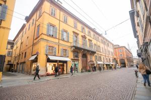 un grupo de personas caminando por una calle con edificios en Modena Centro Junior Suite, en Módena