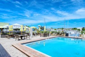 uma piscina num hotel com mesas e cadeiras em Heated Pool, Bunk Beds, King Bed, Huge TV, Marina, Tiki Bar em Sarasota