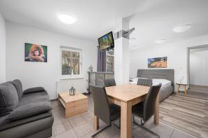 a living room with a table and a bed at Apartmá SunGarden Liberec in Liberec