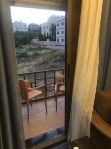 a view from a window of a balcony with chairs at عمان الجبيهة Amman-Aljubiha-near to Jordanian university in Ţāb Kirā‘