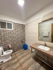 a bathroom with a toilet and a sink and a mirror at Islamabad Travelodge Guest House in Rawalpindi