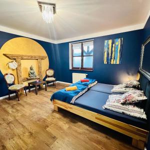 1 dormitorio con paredes azules y 1 cama con sábanas azules en Chata Jaga, en Szklarska Poręba
