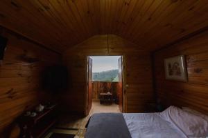 1 dormitorio con 1 cama en una habitación de madera en Cabanas Capivari Lodge, en Campos do Jordão