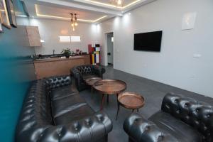 a bar with leather couches and tables and a television at Joumaya Blue Manoir in Casablanca