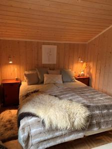 a bedroom with a large bed with a furry blanket at Enok Hytter & Resort in Liagardane