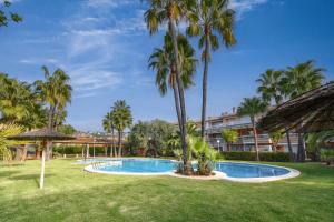 uma piscina com palmeiras e um edifício em Jardines de Gabriel em Xàbia
