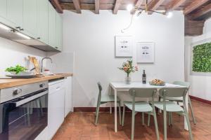 una cucina con tavolo e sedie bianchi di Wine Apartments Florence Ciliegiolo a Firenze