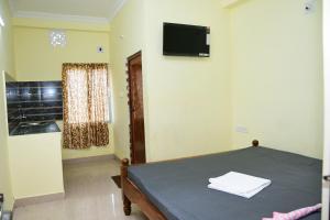 a room with a bed and a television on a wall at HOTEL DREAM PALACE in Puri