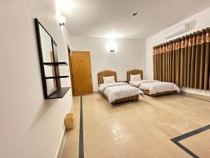 um quarto com 2 camas e um espelho na parede em Islamabad Travelodge Guest House em Rawalpindi