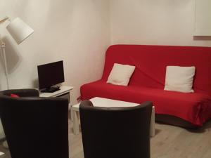 a living room with a red couch and chairs at Studio Valloire, 1 pièce, 4 personnes - FR-1-263-42 in Valloire