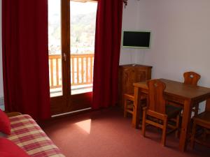 a living room with a table and a television and a table and chair at Appartement Valloire, 2 pièces, 4 personnes - FR-1-263-124 in Valloire