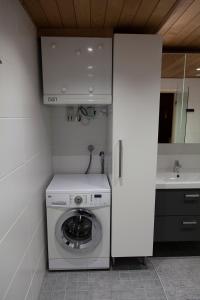 a washing machine in a bathroom with a sink at Seitapolku 12 Villa in Saariselka