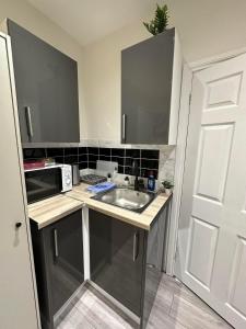 a small kitchen with a sink and a microwave at Nice studio in london in London