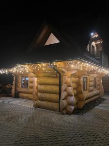 a log cabin with lights on it at night at Osada pod Giewontem 3 - KACPROWY in Czerwienne