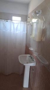 baño con lavabo y cortina de ducha en Cabañas Comodoro en Mina Clavero