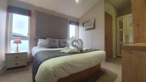 een slaapkamer met een bed met een handdoek erop bij Little Gem Lodge with Hot Tub in Malton