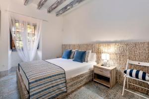 a white bedroom with a bed and a chair at Villa Nice Mallorca in Palma de Mallorca +58 photos