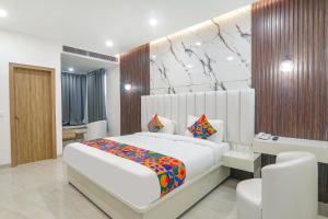 1 dormitorio con 1 cama grande y escritorio en FabHotel Impact en Lucknow