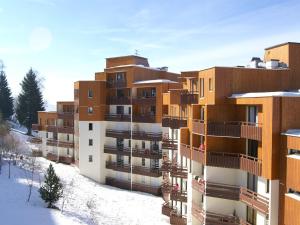 an apartment building with snow on the ground at Studio chaleureux aux Adrets - Face aux pistes, 4ème étage, 2 pers, cuisine équipée - FR-1-557-28 in Les Adrets