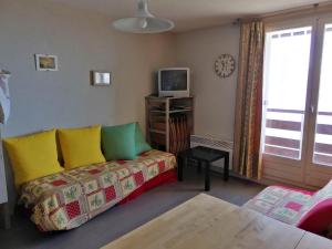 a living room with a couch and a tv at Chaleureux 2P, balcon, proche pistes & commerces - FR-1-557-99 in Les Adrets