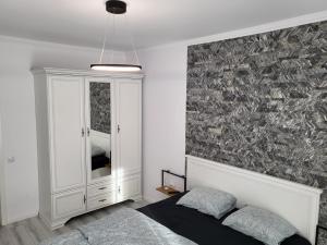 - une chambre avec un lit et un mur recouvert de plumes dans l'établissement Dacrilo Apartments Cluj-Napoca 11, à Cluj-Napoca