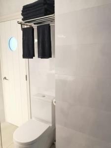 a white bathroom with a toilet and black towels at Apartamento completo en Cadaqués in Cadaqués +5 photos