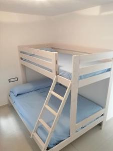 a white bunk bed with a ladder on it at Apartamento completo en Cadaqués in Cadaqués