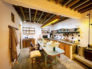 uma grande cozinha com uma mesa e cadeiras em 2 Bedrooms Artist House - The 2nd Home em Da Lat
