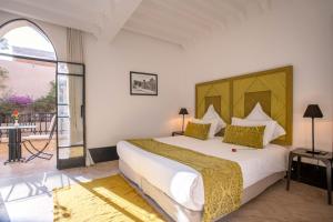 ein Schlafzimmer mit einem großen Bett und einem Balkon in der Unterkunft Riad & Spa Azzouz in Marrakesch