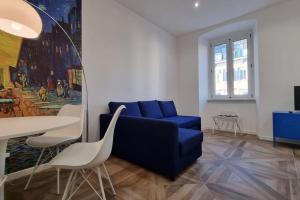 een woonkamer met een blauwe bank en een tafel bij Van Gogh in Trieste