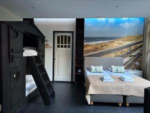 a bedroom with two bunk beds and a view of the ocean at Hotel Heerlijkheid Bergen in Bergen