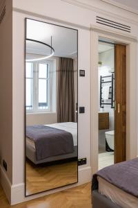 einen Spiegel in einem Schlafzimmer mit einem Bett und einem Badezimmer in der Unterkunft On The Square in Lwiw
