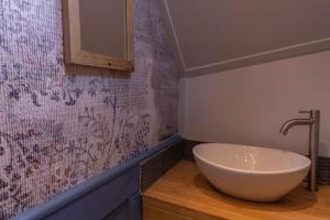 a bathroom with a white bowl sink on a wall at Boutique style ship 10 double cabins in Monnickendam