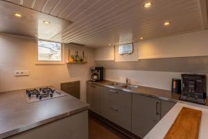 a kitchen with a sink and a stove top oven at Boutique style ship 10 double cabins in Monnickendam