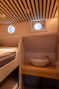 baño pequeño con lavabo y cama en Boutique style ship 10 double cabins, en Monnickendam