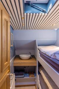 Habitación pequeña con cama y un bol en un estante en Boutique style ship 10 double cabins, en Monnickendam