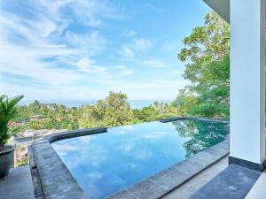 a swimming pool on a patio with a view of the ocean at Villa Mimpi Tamarind in Amed