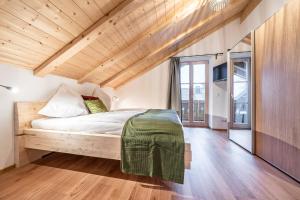 - une chambre avec un lit et un plafond en bois dans l'établissement Alpenrose Ferienwohnungen, à Lenggries