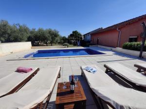 a patio with two beds and a swimming pool at Apartments Villa Sabina in Pula