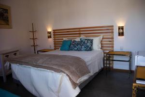 a bedroom with a large bed with blue pillows at POUSADA TONS DA MANTIQUEIRA in Piranguçu