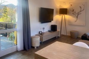 a living room with a flat screen tv on the wall at Ferienwohnung Bergzauber mit Balkon & Bergblick in Schliersee