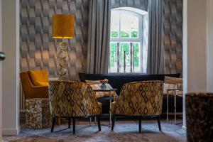 a living room with a table and chairs and a window at Boutique Hotel Slenaker Vallei - Buitengewoongenieten in Slenaken