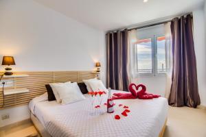 una habitación de hotel con una cama con rosas rojas. en Ideal Property Mallorca - Blue Palm Beach, en Alcudia