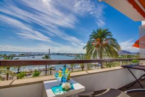 einen Balkon mit einem Tisch und Meerblick in der Unterkunft Ideal Property Mallorca - Blue Palm Beach in Alcúdia
