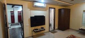 a living room with a television on the wall at Happy Vibes Stay 2Bhk flat in Vānivilāsa Puram